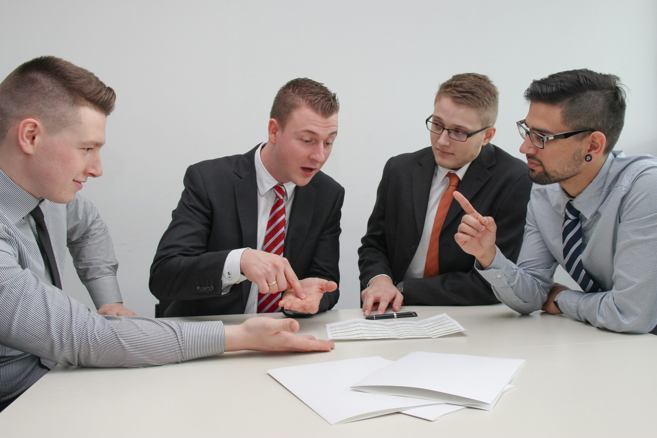 A person sitting at a desk surrounded by papers and holding their head in frustration