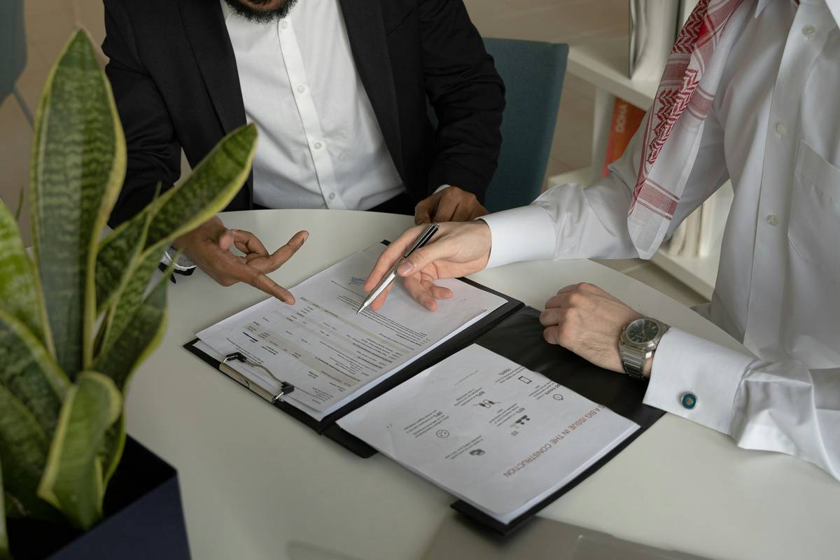 A person stressed over finances, surrounded by bills and a calculator.